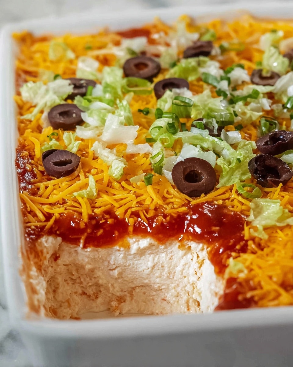 The image shows a close-up of a layered dip in a white rectangular dish, with a section scooped out. The bottom layer is creamy and light beige with smooth texture. Above it is a shiny red salsa layer that partially mixes with the cream below. The next layer is a thick, bright orange shredded cheese spread evenly across the top. On the topmost layer, there are scattered green chopped chives, light green shredded lettuce pieces, and halved black olives with a deep purple shade. The dish sits on a white marbled surface. Photo taken with an iphone --ar 4:5 --v 7
