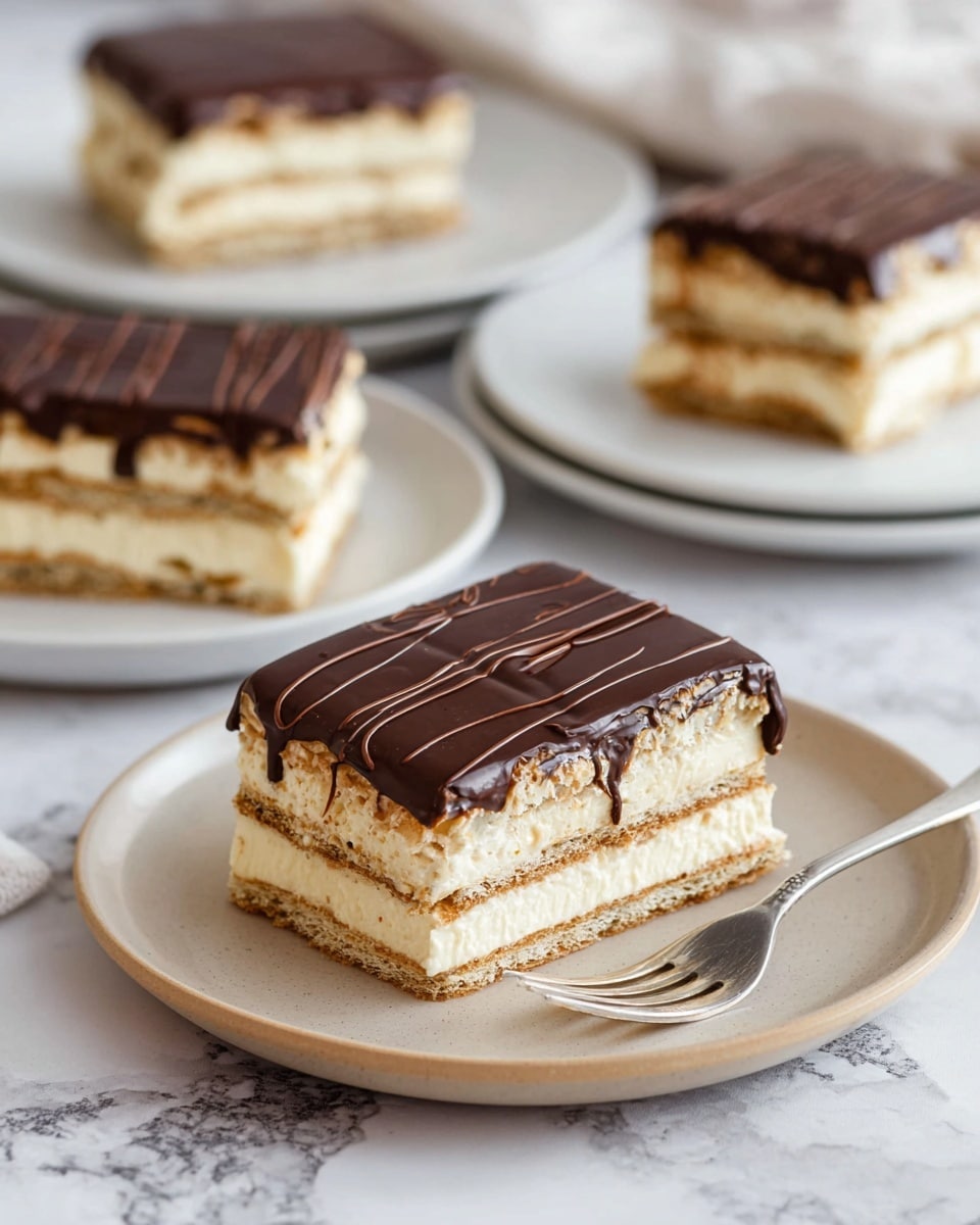 The image shows four square slices of a layered dessert on white plates set on a white marbled surface. Each slice has three main layers of creamy pale filling alternating with two layers of light brown, crispy wafer. The top layer is smooth, glossy dark chocolate with darker chocolate lines drizzled across it. The closest slice is on a round beige plate with a silver fork resting beside it, and the other slices are blurred in the background on white plates. Photo taken with an iphone --ar 4:5 --v 7