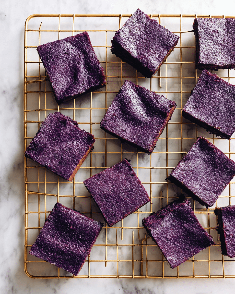 Several square brownies with a deep purple color and a slightly shiny, textured top are arranged casually on a gold wire cooling rack. The brownies have a thick layer showing their dense texture. The cooling rack sits on a white marbled surface that brightens the dark purple hue of the brownies. The arrangement is evenly spaced but informal, showing the brownies from a top-down view. photo taken with an iphone --ar 4:5 --v 7