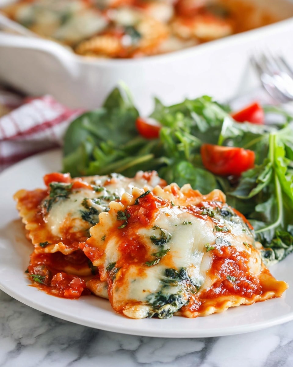A white oval baking dish filled with a layered ravioli casserole is shown. The bottom layer is a thick, chunky red tomato sauce mixed with bright green cooked spinach leaves. Above this is a layer of large, creamy white ravioli pasta pieces partly covered by more tomato sauce and spinach. The top layer is melted white mozzarella cheese spread thickly and topped with small pieces of fresh green basil. A large metal spoon is scooping out some ravioli from one side, showing the layers inside. The dish sits on a white marbled surface next to a white plate. Photo taken with an iphone --ar 4:5 --v 7
