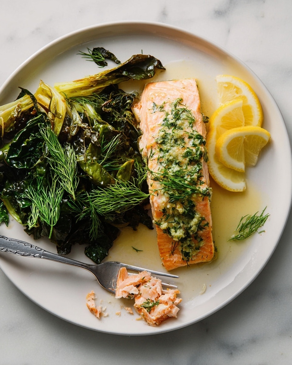 A white plate holds a cooked salmon fillet placed slightly right of center, showing a light pink color with green herb sauce and dill on top. To the left of the salmon, there are dark green cooked leafy vegetables with some charred edges, topped with a few fresh dill sprigs. Thin, yellow lemon slices rest beside the vegetables. A silver fork with some broken salmon flakes sits on the left edge of the plate. The surface underneath the plate is white with a marbled texture. Photo taken with an iphone --ar 4:5 --v 7