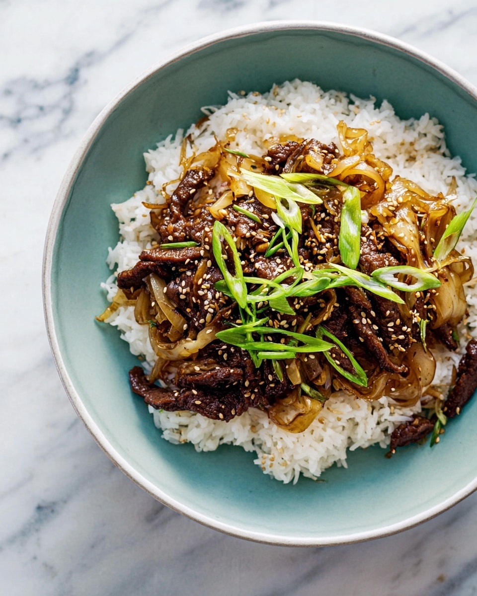 In a deep white bowl, there is a layer of white steamed rice on the right side, fluffy and soft in texture. On top and overlapping the rice, there is a mix of dark brown, caramelized beef slices with a glossy sauce, mixed with light brown, sautéed thin onion strips. Scattered over the beef and onions are tiny white sesame seeds, and bright green, thinly sliced scallions spread across the middle, adding a fresh contrast. The bowl sits on a white marbled textured surface, creating a clean and simple background. Photo taken with an iphone --ar 4:5 --v 7