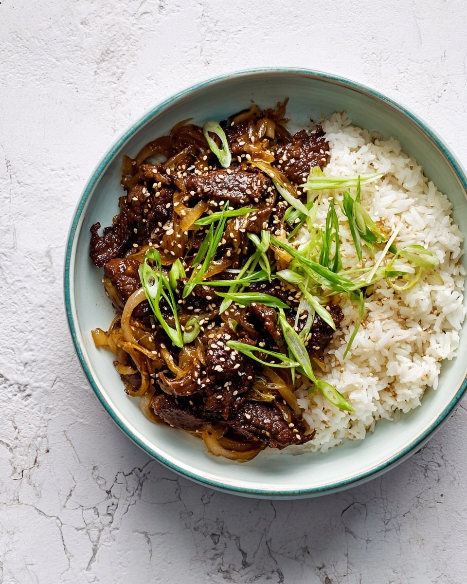 A white bowl holds a serving of cooked white rice as the base layer, soft and fluffy with some sesame seeds sprinkled, mostly on the rice. On top, there is a darker layer of stir-fried beef mixed with light brown cooked onions and shredded cabbage, showing a glossy, slightly oily texture. Thin strips of bright green scallions are scattered on top, adding freshness and color contrast. The bowl is on a white marbled surface. photo taken with an iphone --ar 4:5 --v 7