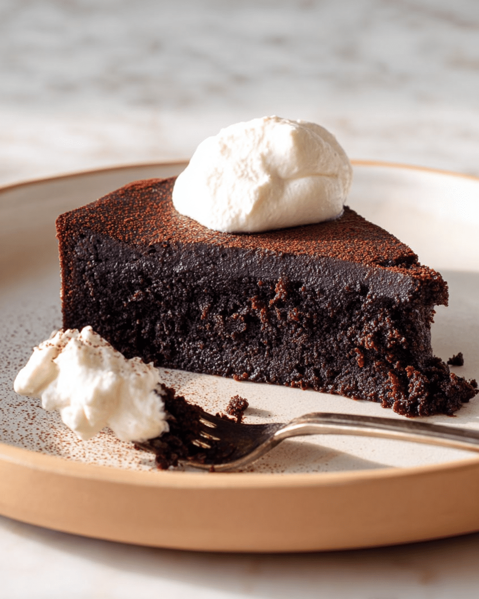 A close-up of a thick slice of dark chocolate cake with a slightly cracked top layer and a dense, moist texture underneath, topped with a dollop of smooth white cream. The slice sits on a white plate with a beige rim, with a shiny fork resting next to it holding some crumbs and a bit of white cream. The background is a white marbled texture. photo taken with an iphone --ar 4:5 --v 7