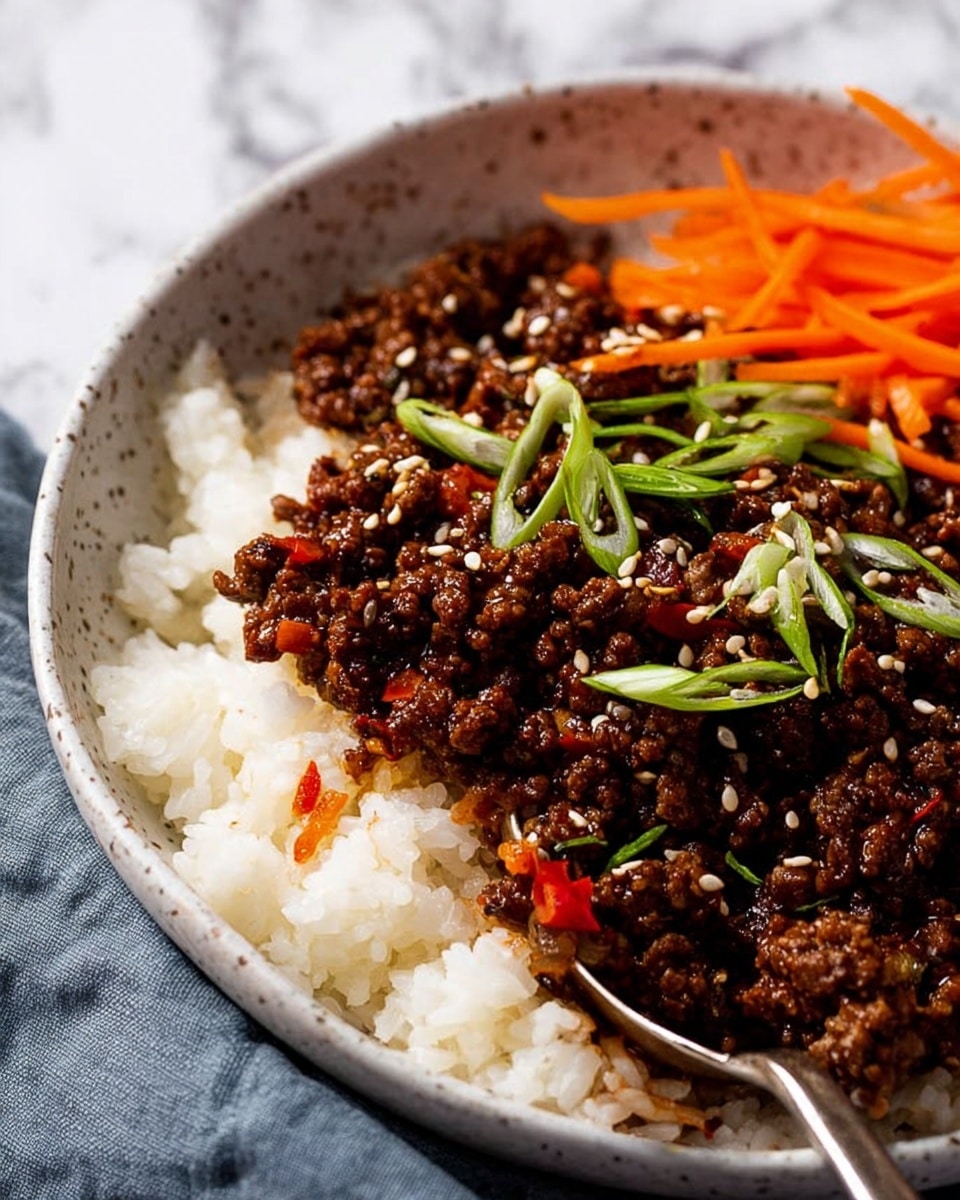 A close-up view of a bowl with two main layers: the bottom layer is white steamed rice with a soft, fluffy texture, and the top layer is dark brown cooked minced meat mixed with some red chili pieces, garnished with white sesame seeds and thin green scallion slices. There are thin, bright orange carrot strips positioned on one side of the bowl. The bowl is white with a subtle speckled pattern, and a silver spoon is partially visible on the right side, scooping some rice and meat. The background is a white marbled texture with a soft cloth visible in the back. Photo taken with an iphone --ar 4:5 --v 7