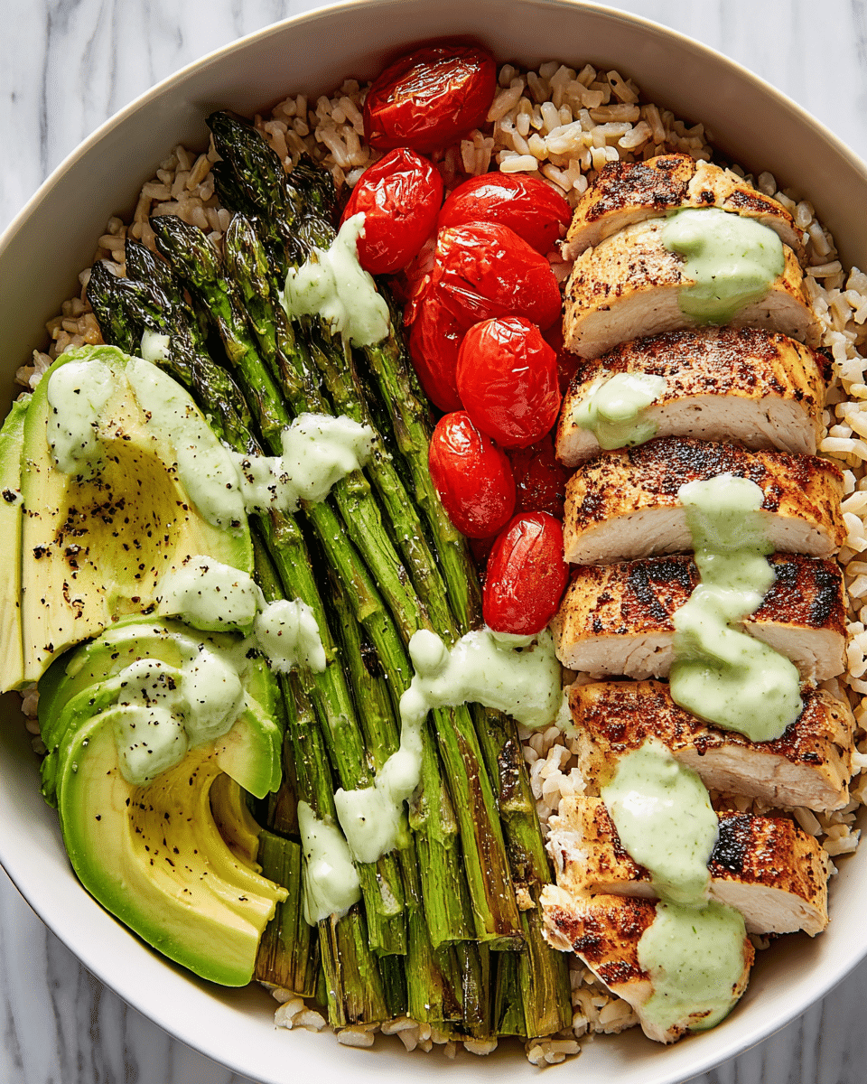 A white bowl filled with a base layer of light brown cooked rice, topped with a layer of grilled green asparagus spears arranged side by side. On one side, there are bright red halved cherry tomatoes and light green avocado slices sprinkled with black pepper. On the other side, there are sliced pieces of golden-brown grilled chicken breast placed in a neat row. A pale green creamy dressing is drizzled over the asparagus, tomatoes, avocado, and chicken. The bowl is set on a white marbled surface. photo taken with an iphone --ar 4:5 --v 7