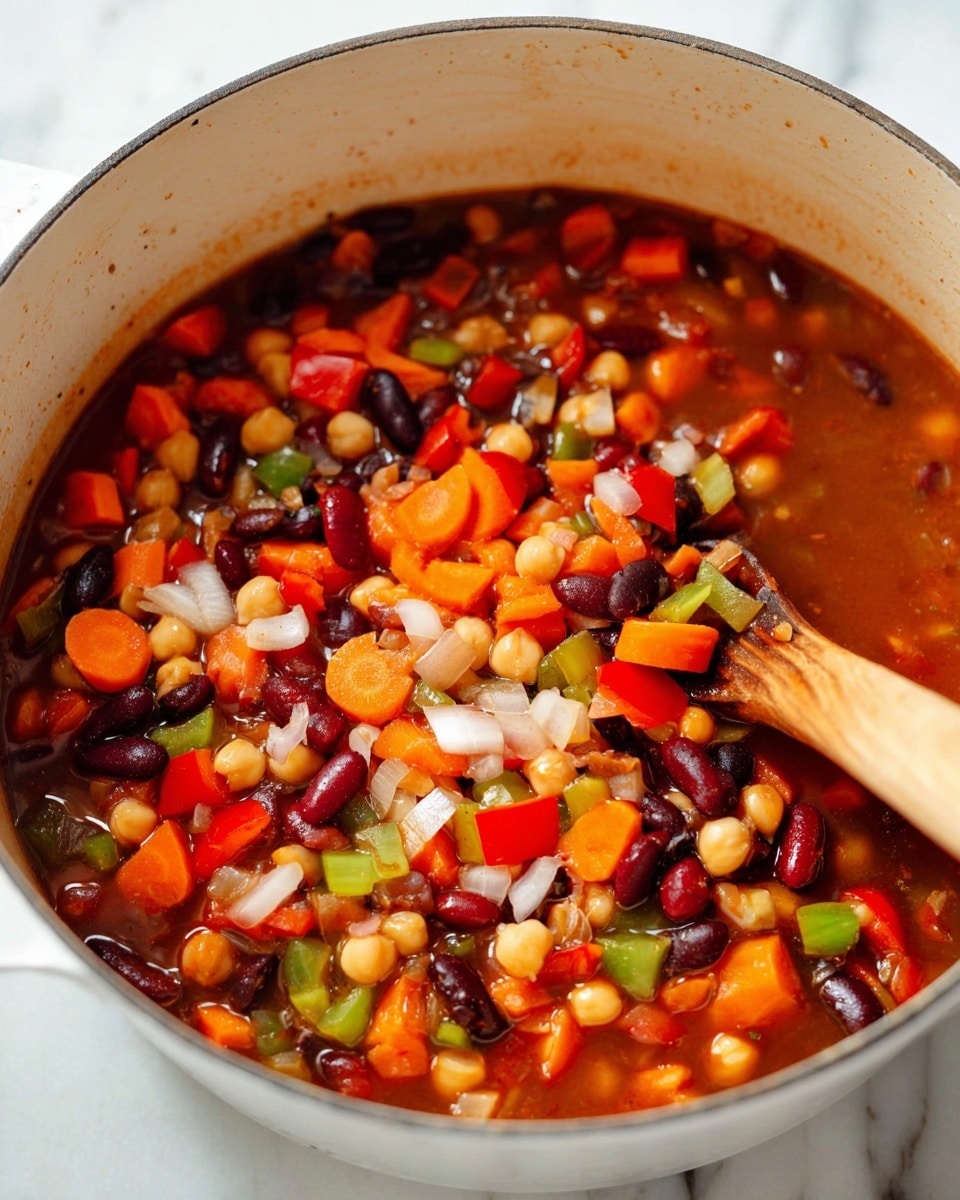A close-up view of a white pot filled with a colorful mixed vegetable stew. The dish has multiple visible layers: a base layer of reddish-brown broth is speckled with chopped white onions and diced red and green bell peppers; scattered through this are thick orange carrot slices and beans in dark red, black, and beige colors, along with chickpeas. The ingredients have a soft, cooked texture and are mingled together. Part of a wooden spoon is visible in the bottom right corner, stirring the vibrant mix. The pot sits on a white marbled surface. photo taken with an iphone --ar 4:5 --v 7