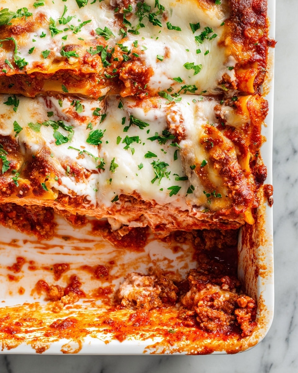 A close-up of a white baking dish with a partially eaten lasagna showing three visible layers: a bottom layer of rich red tomato sauce with bits of browned ground meat, a middle layer of pasta sheets and a creamy pinkish mixture of ricotta cheese or béchamel, and a thick top layer of melted white mozzarella cheese with spots of golden brown, sprinkled with chopped fresh green parsley. The edges of the dish have splashes of tomato sauce, and the background is a white marbled surface. photo taken with an iphone --ar 4:5 --v 7