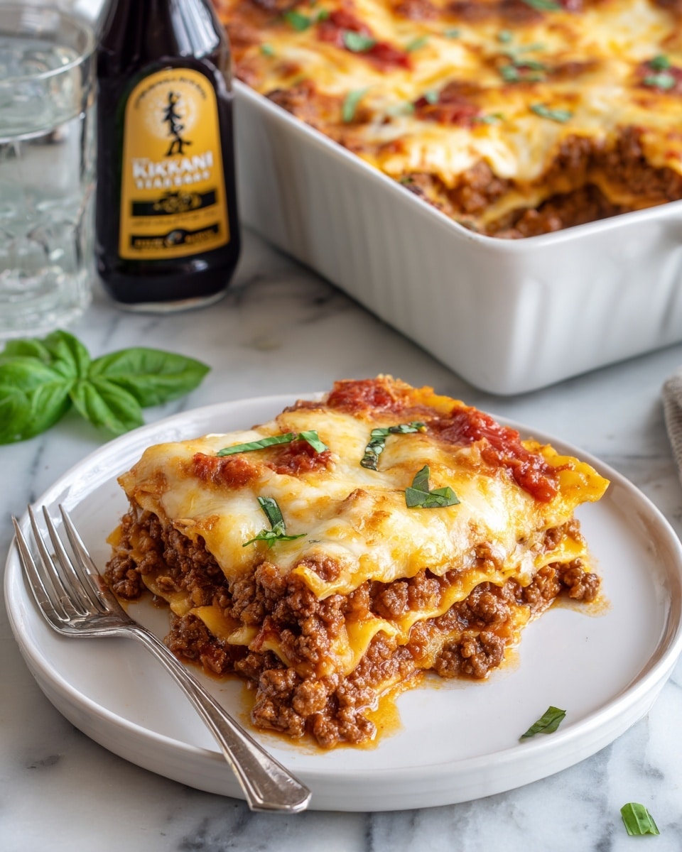 A white plate holds a piece of lasagna with three visible layers: the bottom layer is a golden pasta sheet, the middle layer is thick with cooked ground meat and tomato sauce, and the top layer is melted cheese with some tomato sauce and small green basil leaves sprinkled on top. A silver fork rests on the left side of the plate. Next to the plate, there is a white casserole dish filled with lasagna, showing a similar layered texture with browned melted cheese on top. A large bottle of Kikkoman Roasted Garlic Teriyaki sauce lies below the casserole dish on a white marbled surface, and a glass of water and green basil leaves are partly visible in the upper left area of the image. The photo was taken with an iphone --ar 4:5 --v 7