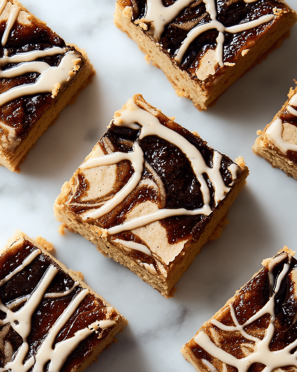 The image shows square-shaped bars with two visible layers. The bottom layer is thick, light brown, and cookie-like in texture. The top layer is a thin, dark brown swirl pattern mixed with a light beige glaze drizzled in an abstract way across each square. The bars are placed closely on a white marbled surface, showing a crumbly texture on the edges. Photo taken with an iphone --ar 4:5 --v 7