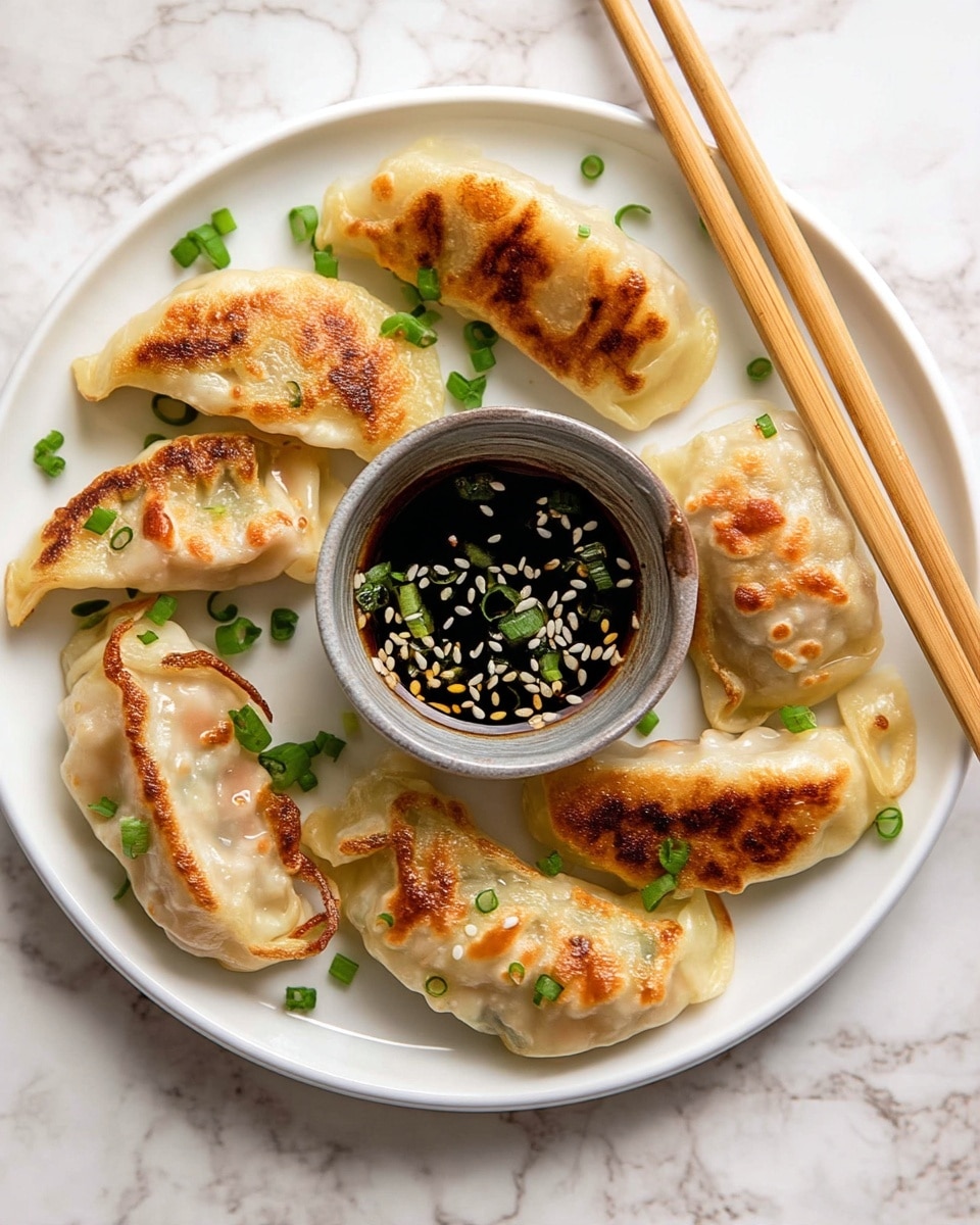 A round white plate holds seven pan-fried dumplings arranged loosely around a small rustic bowl of dipping sauce. The dumplings have a light golden-brown crisp on their surface with soft, creamy white dough showing underneath. The bowl in the center contains a brown soy-based sauce with small pieces of green chopped scallion floating on top, adding a fresh pop of color. The whole scene is set on a white marbled surface that enhances the clean and simple presentation. photo taken with an iphone --ar 4:5 --v 7