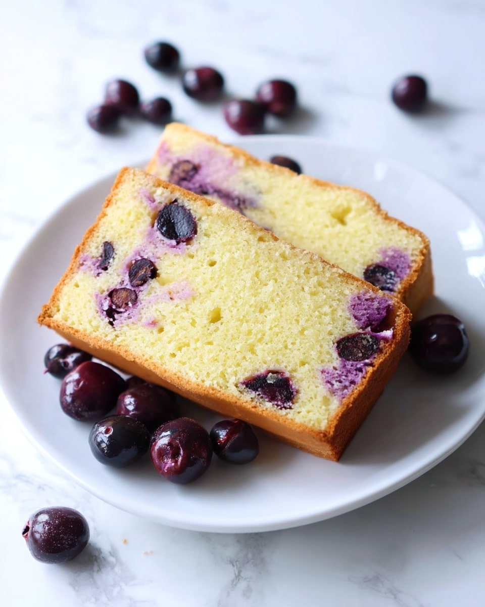 Two slices of light yellow vanilla blueberry cake are stacked on a white plate with ridged edges, placed on a white marbled surface. The cake has a soft and moist texture with a thin golden brown crust on the outside. Inside the slices, there are visible dark purple blueberries and purple streaks from the blueberry juice running through the cake layers. Several whole blueberries are scattered around the plate, some with juice stains on the white marbled surface. photo taken with an iphone --ar 4:5 --v 7
